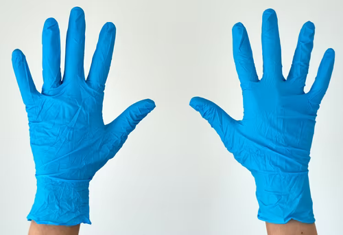 Human rising hands wearing blue disposable latex glove