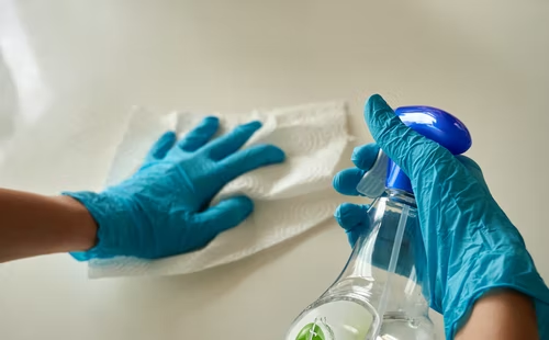 Person wearing blue gloves cleaning